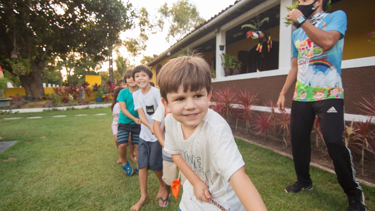 Children enjoy a tug-of-war game outdoors, celebrating teamwork and fun in a garden.